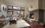Living room with gas fireplace, ample seating, and mountain views.